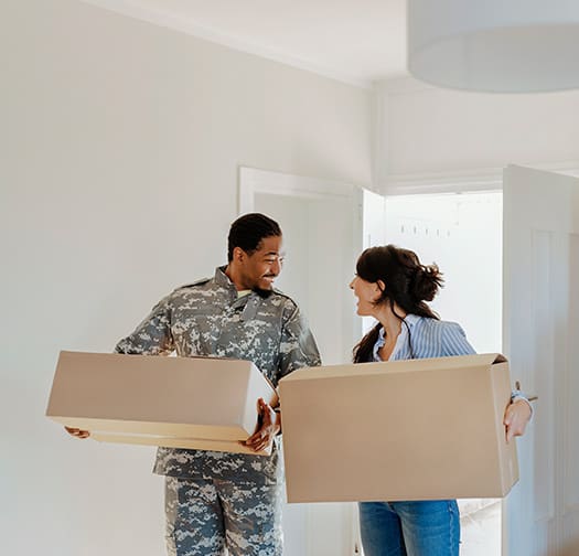 A military couple moving boxes.
