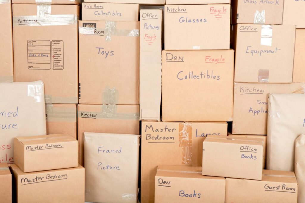 Stacks of cardboard boxes, all labeled with rooms and types of items 