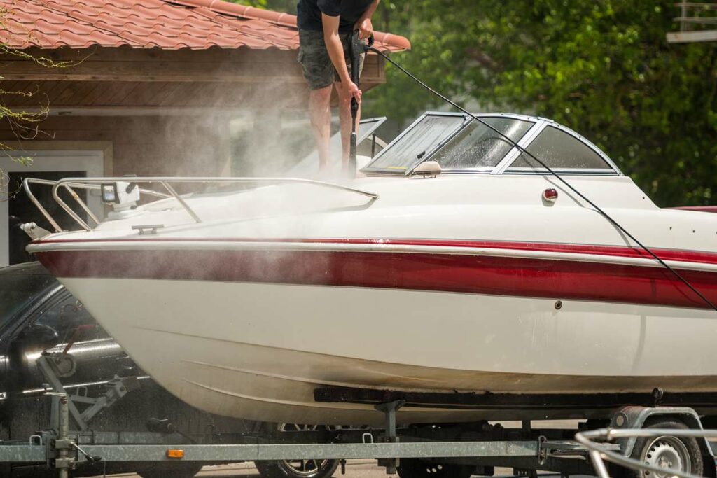 Person power washing a boat