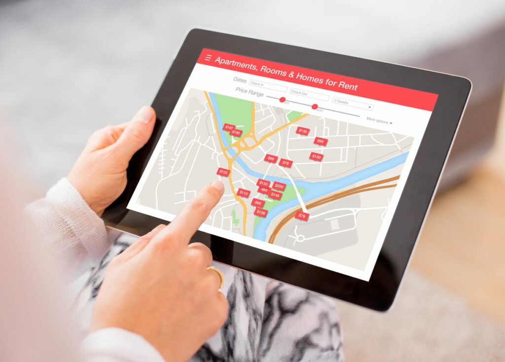 A man navigating an apartment finder website on a tablet