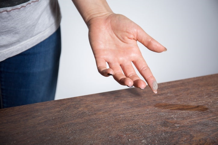  A hand wiping dust off a table