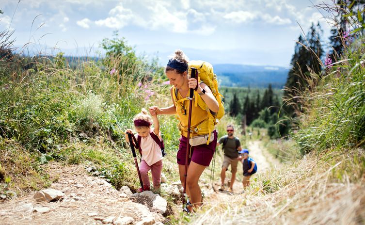 A family of four hikes through a trail