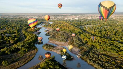 Hot air balloons floating over a fork in the Rio Grande River in Albuquerque