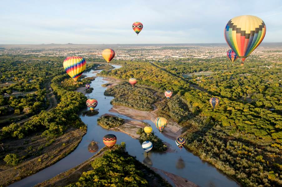 Hot air balloons floating over a fork in the Rio Grande River in Albuquerque