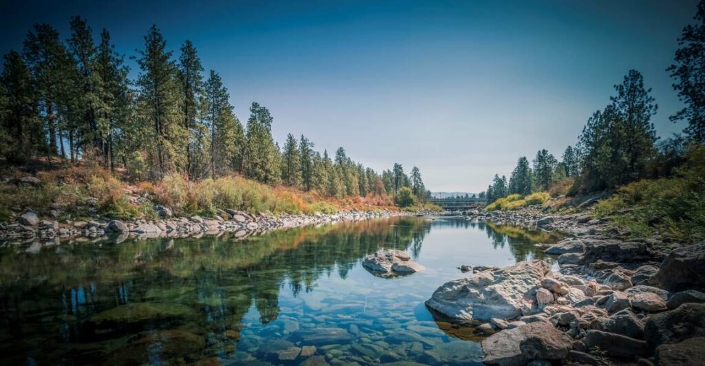 A clear blue river surrounded by trees in Spokane, WA