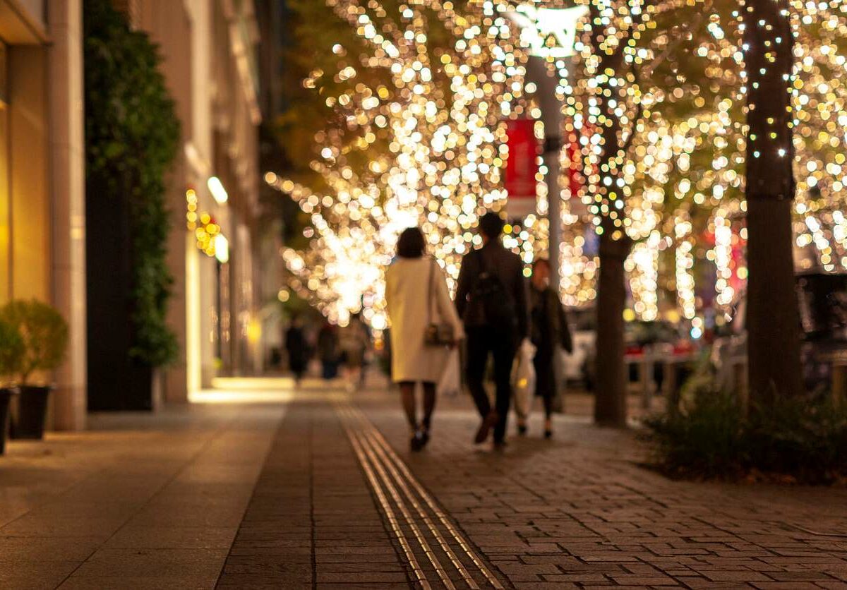 Couple walking together while viewing holiday lights in town.