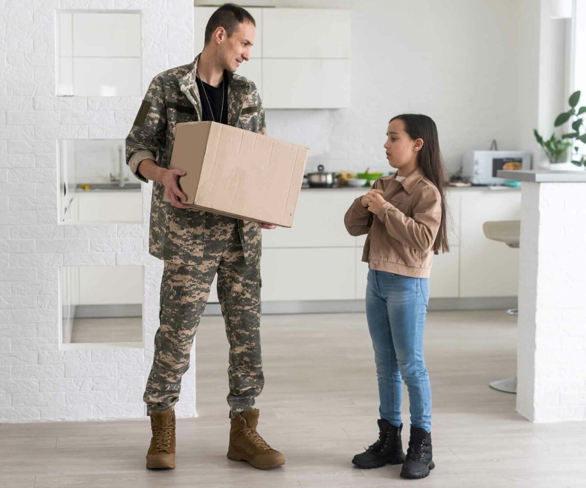 Military father holding a box to store items in a storage unit.