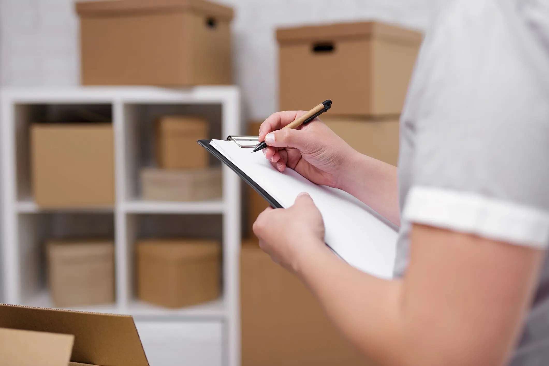 Man creating an inventory list of items being put in a storage unit. 