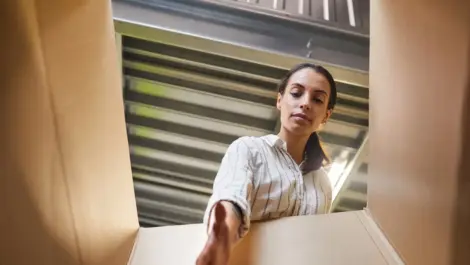 A young woman reaching into a box while loading a storage unit.
