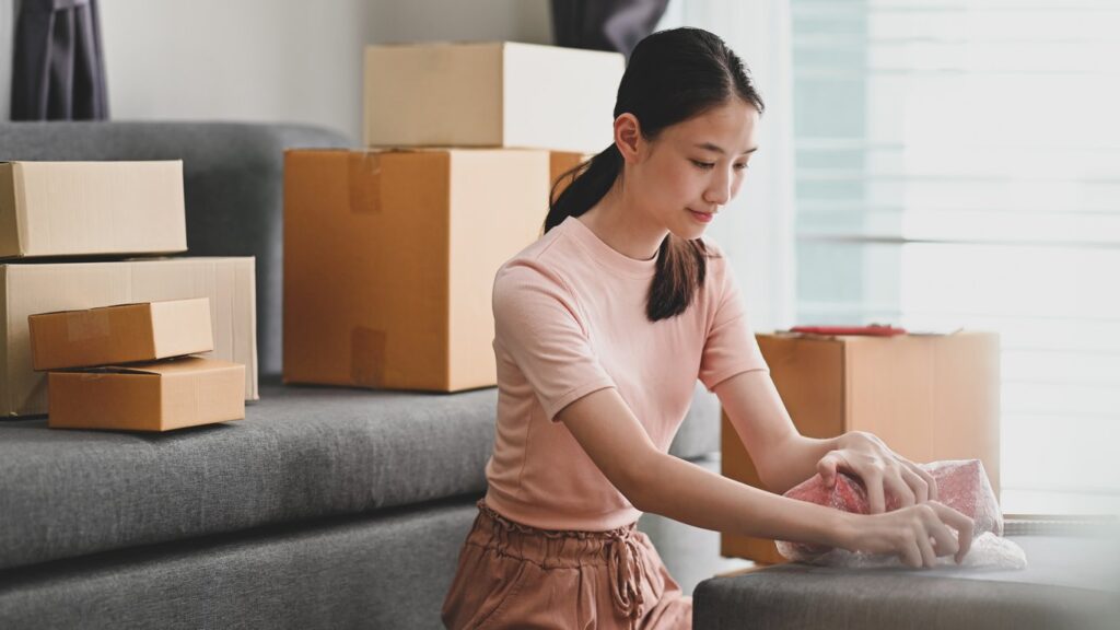 A young woman preparing items for storage. 