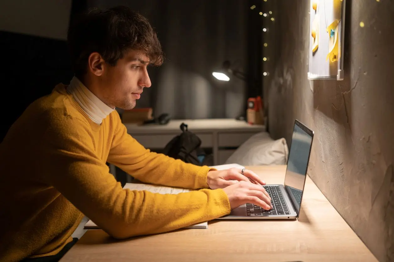 College student studying at his desk. 