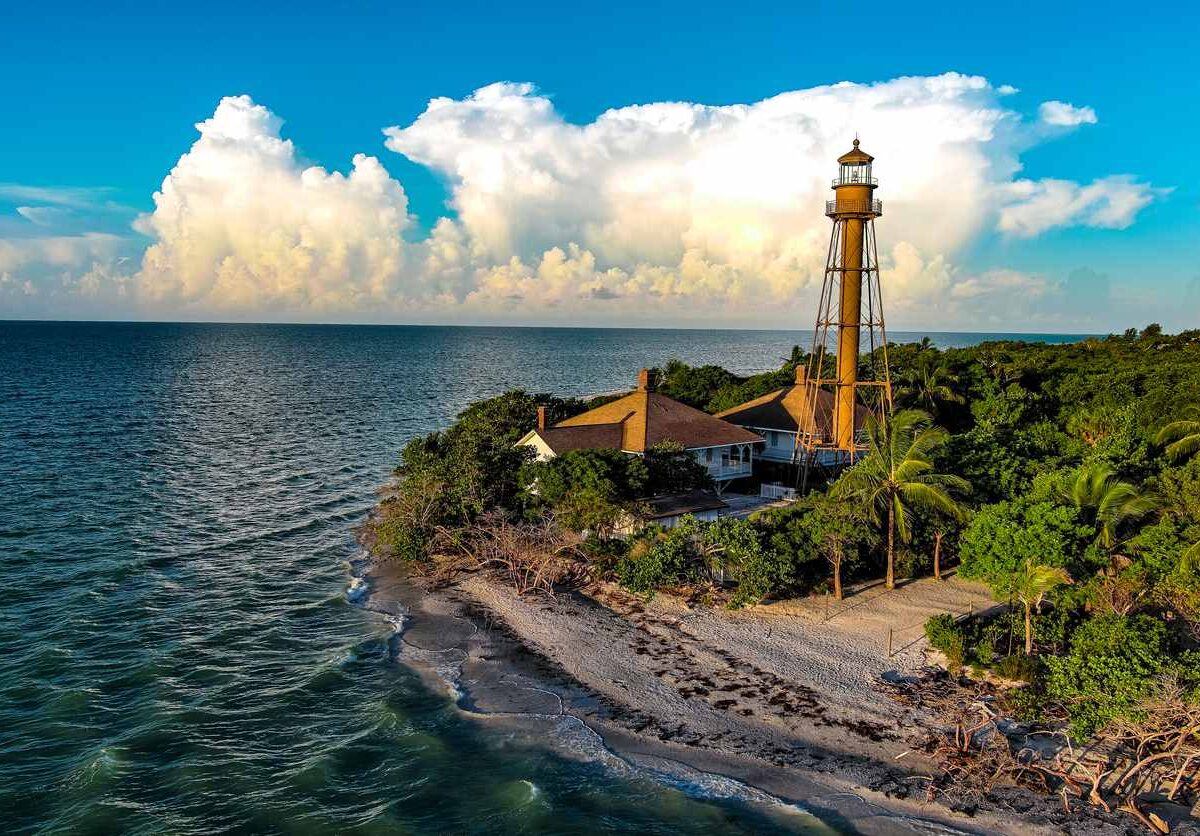 Aerial view of the historic Sanibel Island lighthouse on a sandy coastline.