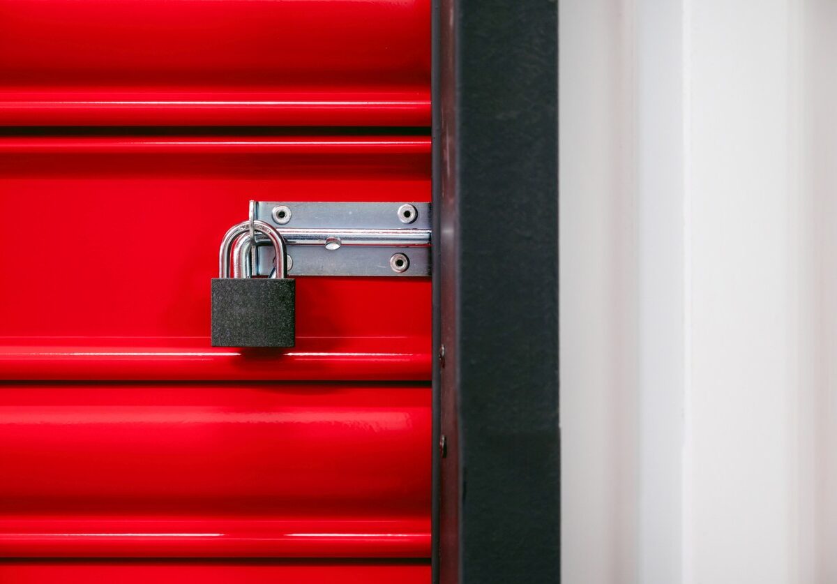 A padlock on a red self storage door.